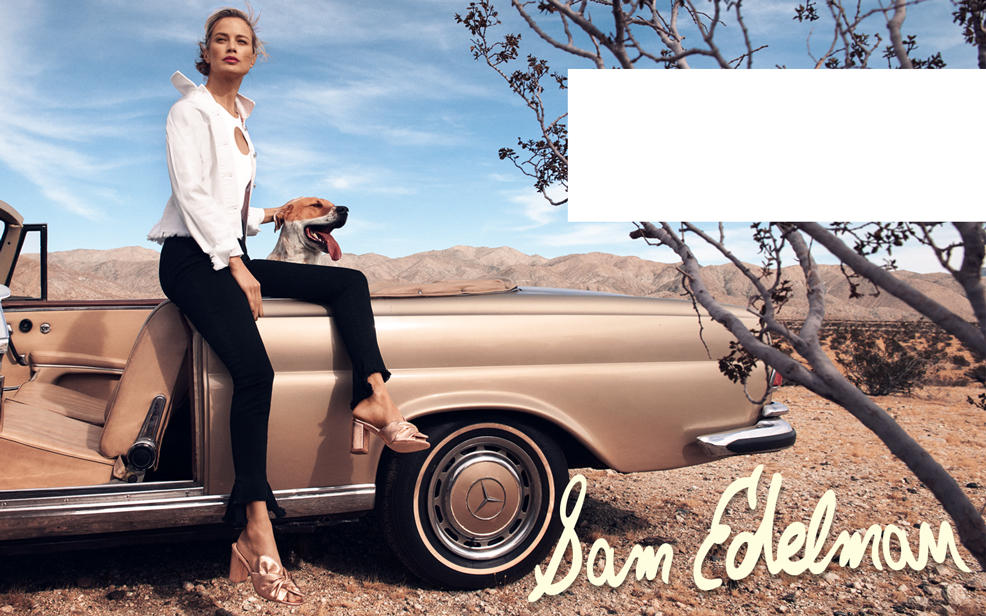 Sam Edelman. A woman pets a dog while sitting in a classic car