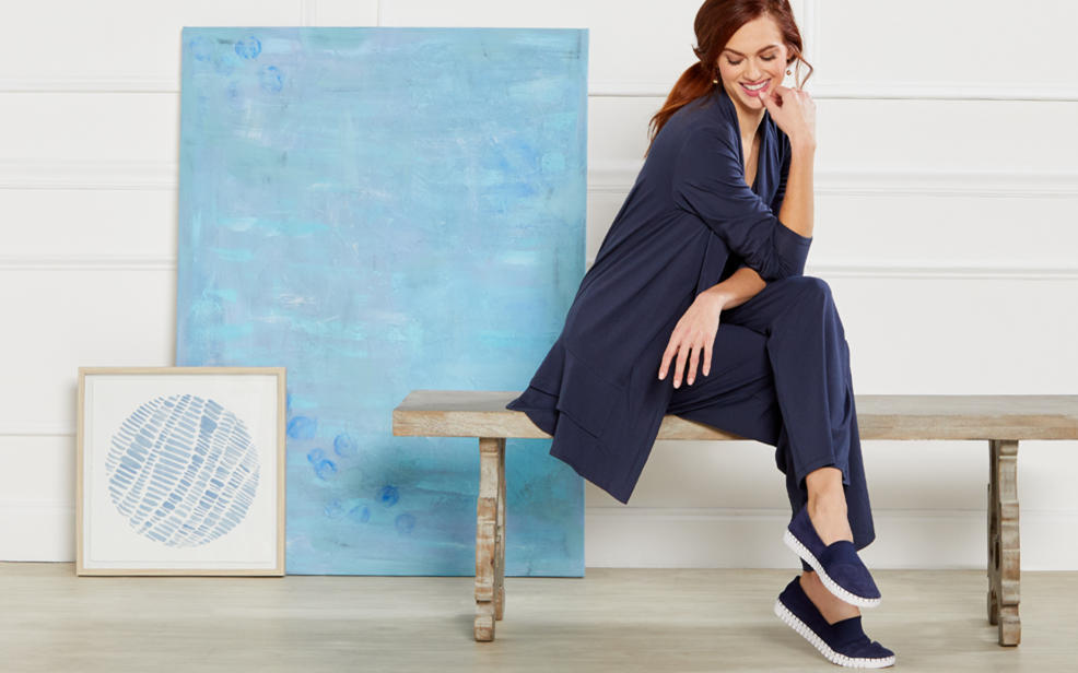 a woman in blue pajamas and blue sneakers.