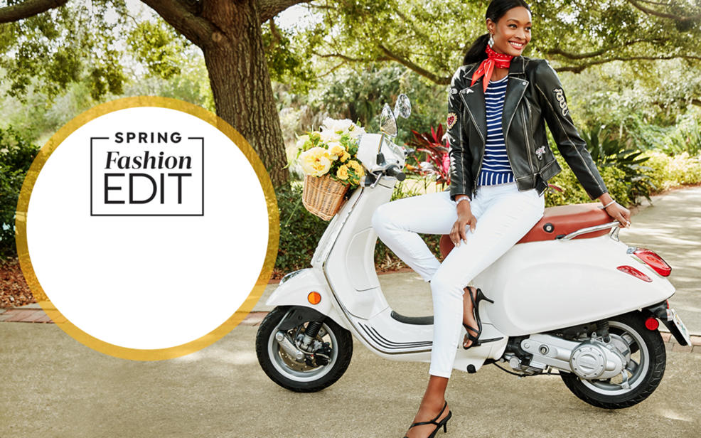 spring fashion edit. a woman on a scooter wearing a decorated jacket