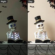 Glitzhome 10.25in. H Halloween Lighted Resin Skull Book Table Decor